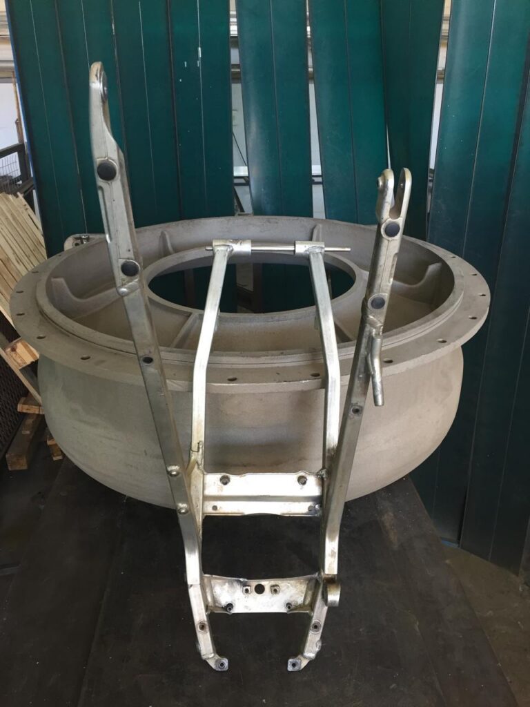 Motorcycle frame repaired alongside a large cast housing.
