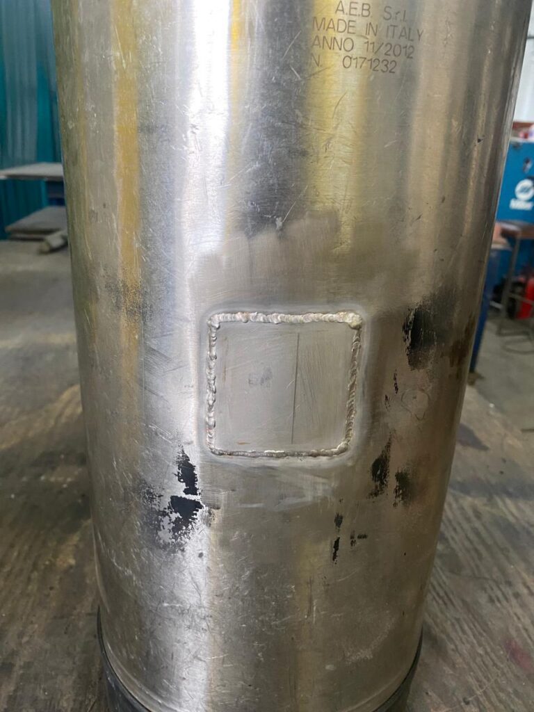 Stainless steel tank with a welded access hatch.